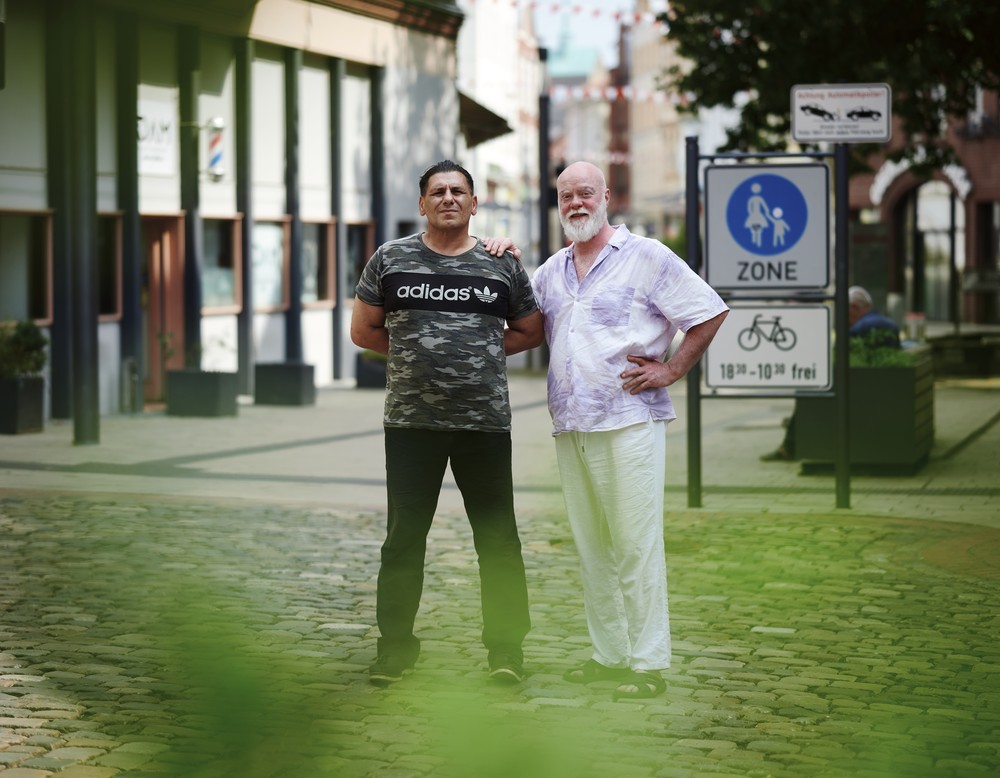 Zwei Männer stehen in einer Straße nebeneinander