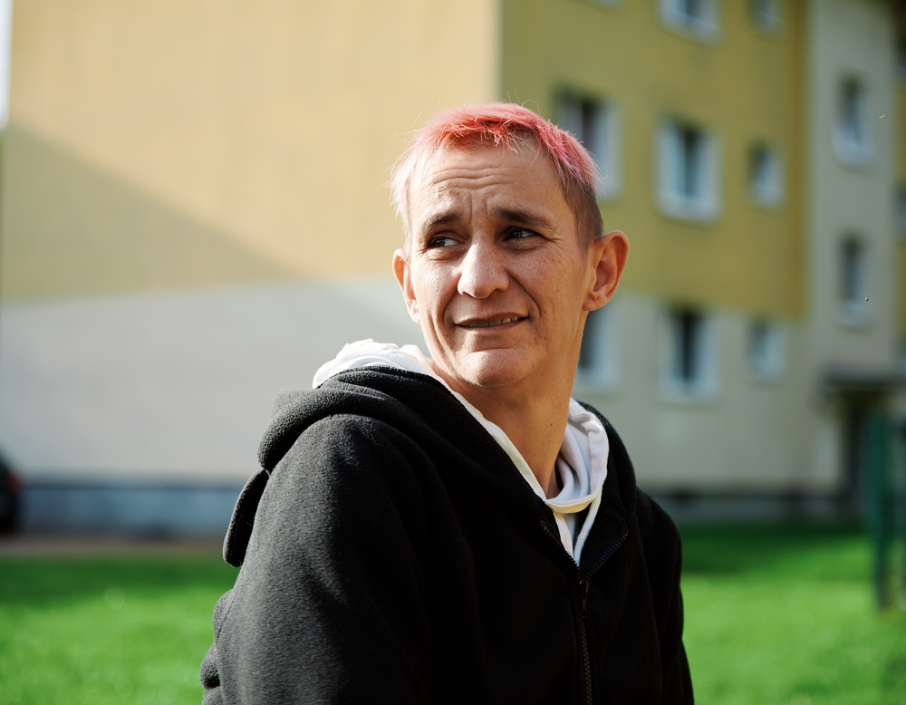 Portrait einer Frau vor einem Wohnhaus
