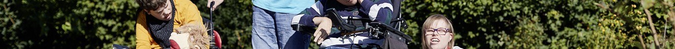 Eine Gruppe junger Menschen mit Behinderungen in einem Garten.